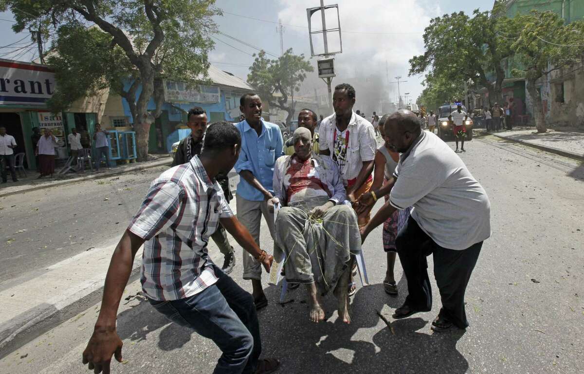 Rescuers carry away a man who was wounded in a car bomb attack in Mogadishu, Somalia Monday, March 13, 2017. A suicide car bomber detonated near the Weheliye hotel in the capital Monday morning, killing a number of people on the busy Maka Almukarramah road, police said. (AP Photo/Farah Abdi Warsameh)