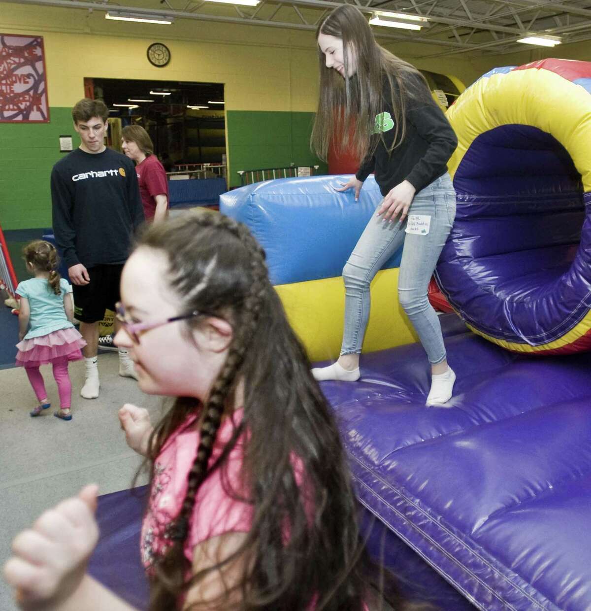 Kally Trudeau, 13 of New Milford, comes out of the Obstacle Course at the Children's Movement Center with New Milford High School sophomore Faith Rosenhagen, right, as part of the high school's Unified Buddies program. Monday, April 3, 2017