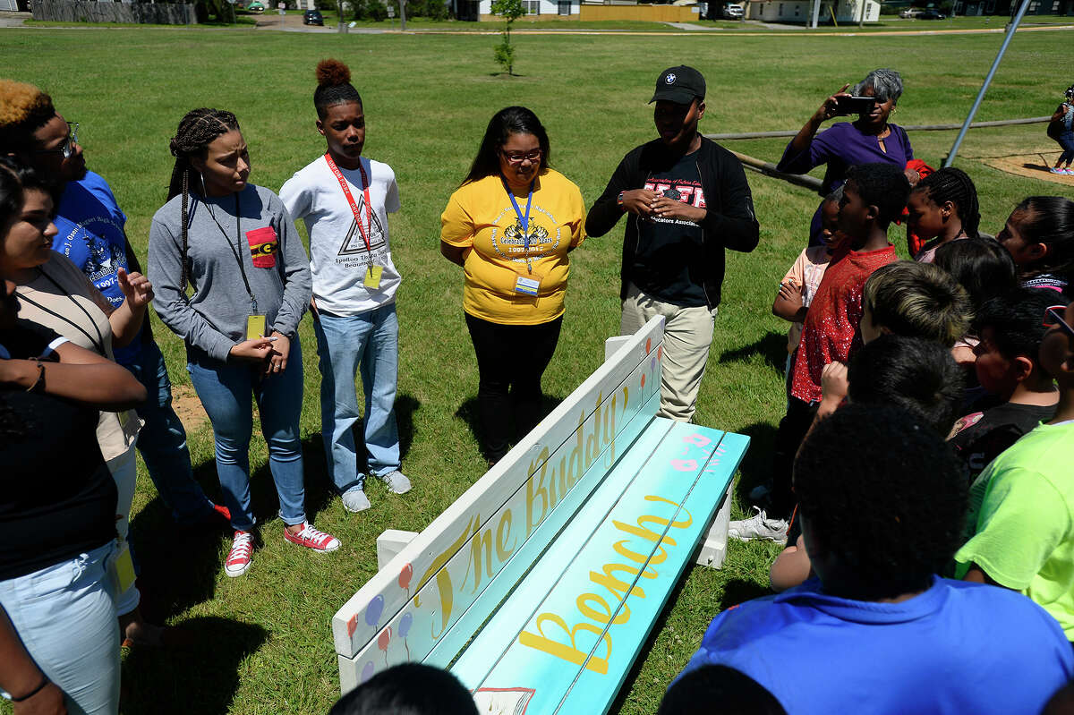 Ozen High School students from Youth Leadership Southeast Texas talk with fourth graders about a new buddy bench on the playground at Jones-Clark Elementary School on Tuesday. The bench will give students a place to sit and find new friends when they don't have anyone to play with. Photo taken Tuesday 4/4/17 Ryan Pelham/The Enterprise