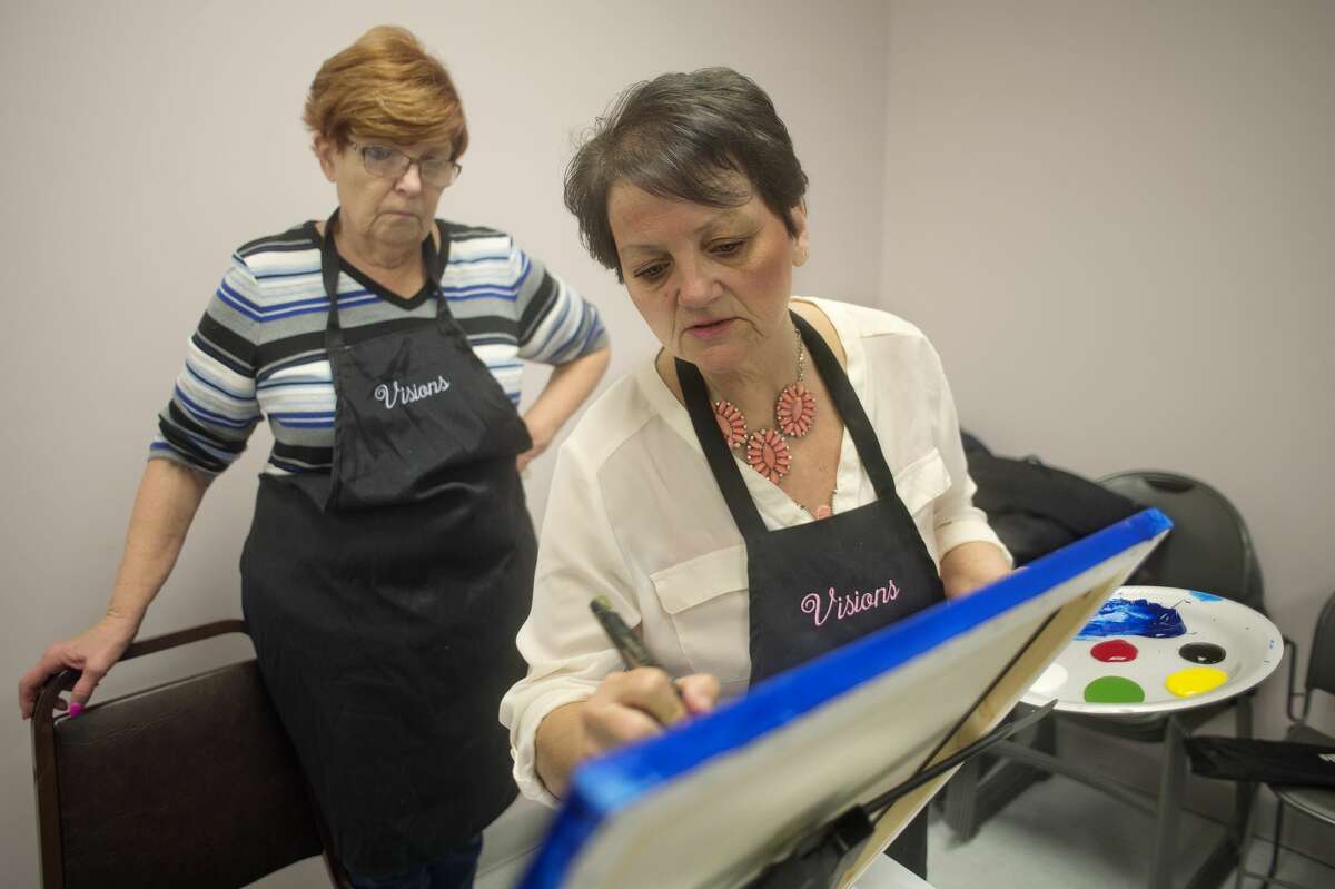 Visions by Vicki founder Vicki Thomas shows Susan Klich, of Midland how to blend her paint during a two hour painting class at Trailside Senior Center Thursday morning. Thomas teaches all ages in two hour sessions and has created more than 100 different paintings.