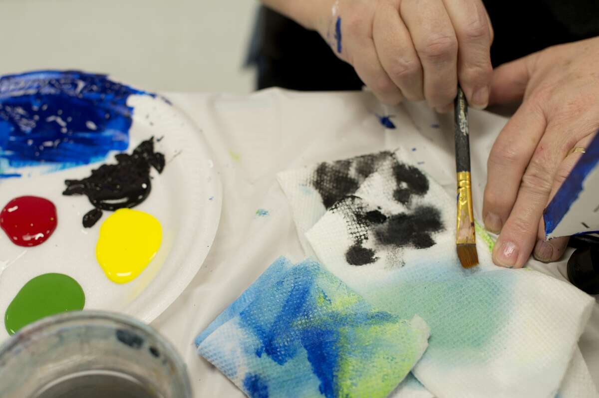 Linda Tefft of Midland cleans her paint brush during a painting class taught by Vicki Thomas through her business Visions by Vicki at Trailside Senior Center Thursday morning.
