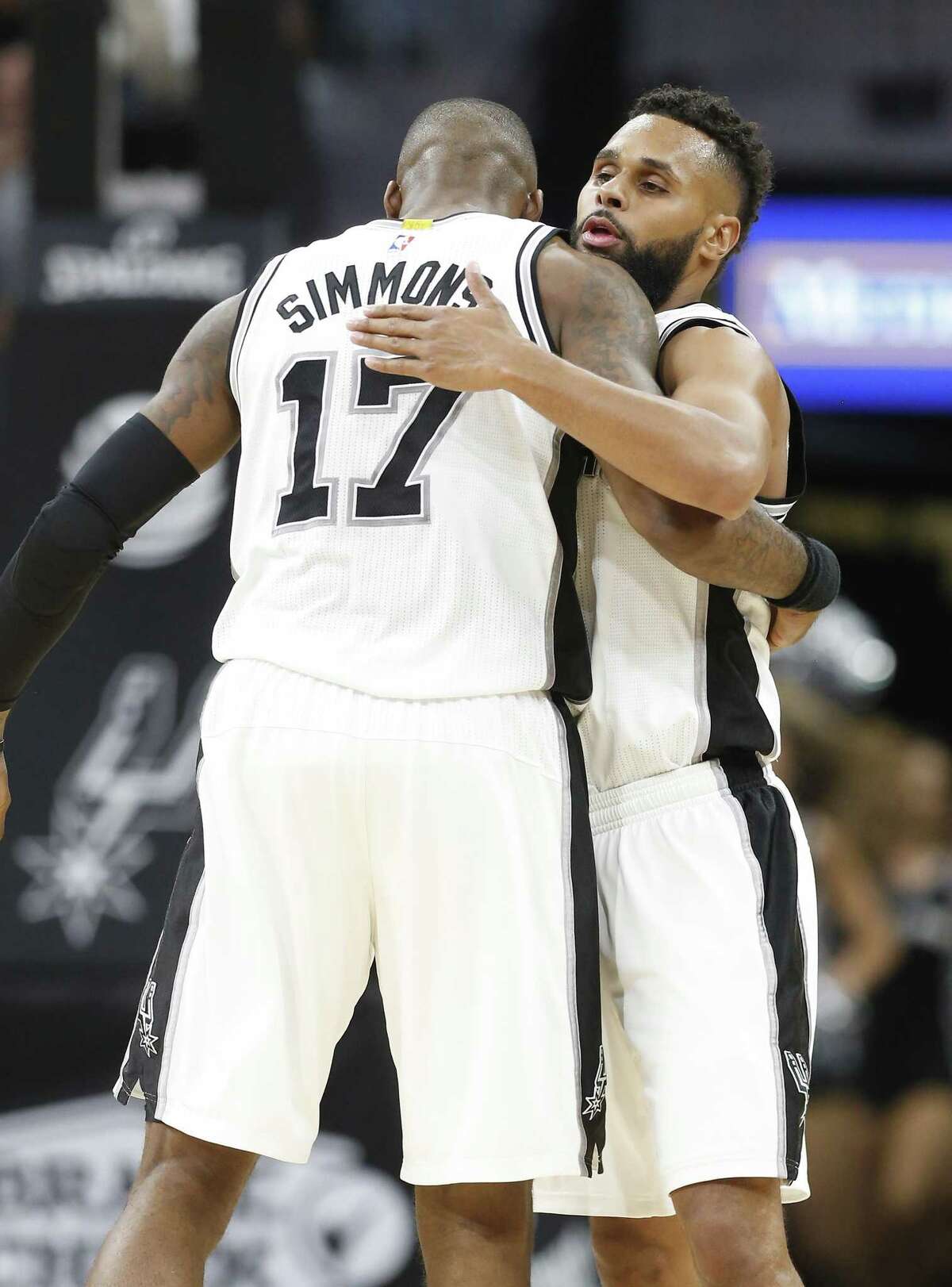 Spurs' Patty Mills (08) gets a hug from teammate Jonathon Simmons (17) after hitting a three-pointer in overtime against the Memphis Grizzlies during their game at the AT&T Center on Tuesday, Apr. 4, 2017. Spurs defeated the Grizzlies in overtime, 95-89. (Kin Man Hui/San Antonio Express-News)
