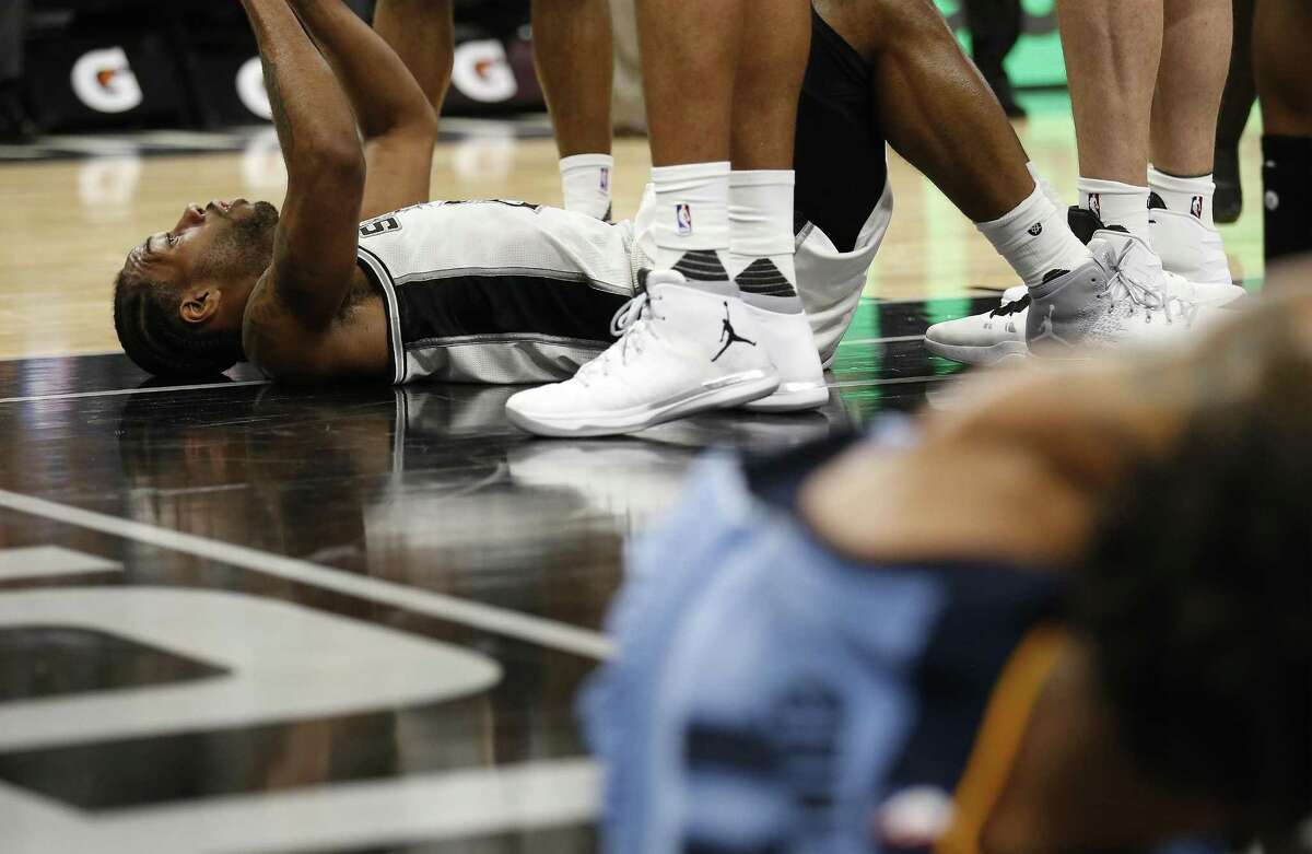 Spurs' Kawhi Leonard (02) lays on the floor after colliding with Memphis Grizzlies' Mike Conley (11) during their game at the AT&T Center on Tuesday, Apr. 4, 2017. Spurs defeated the Grizzlies in overtime, 95-89. (Kin Man Hui/San Antonio Express-News)