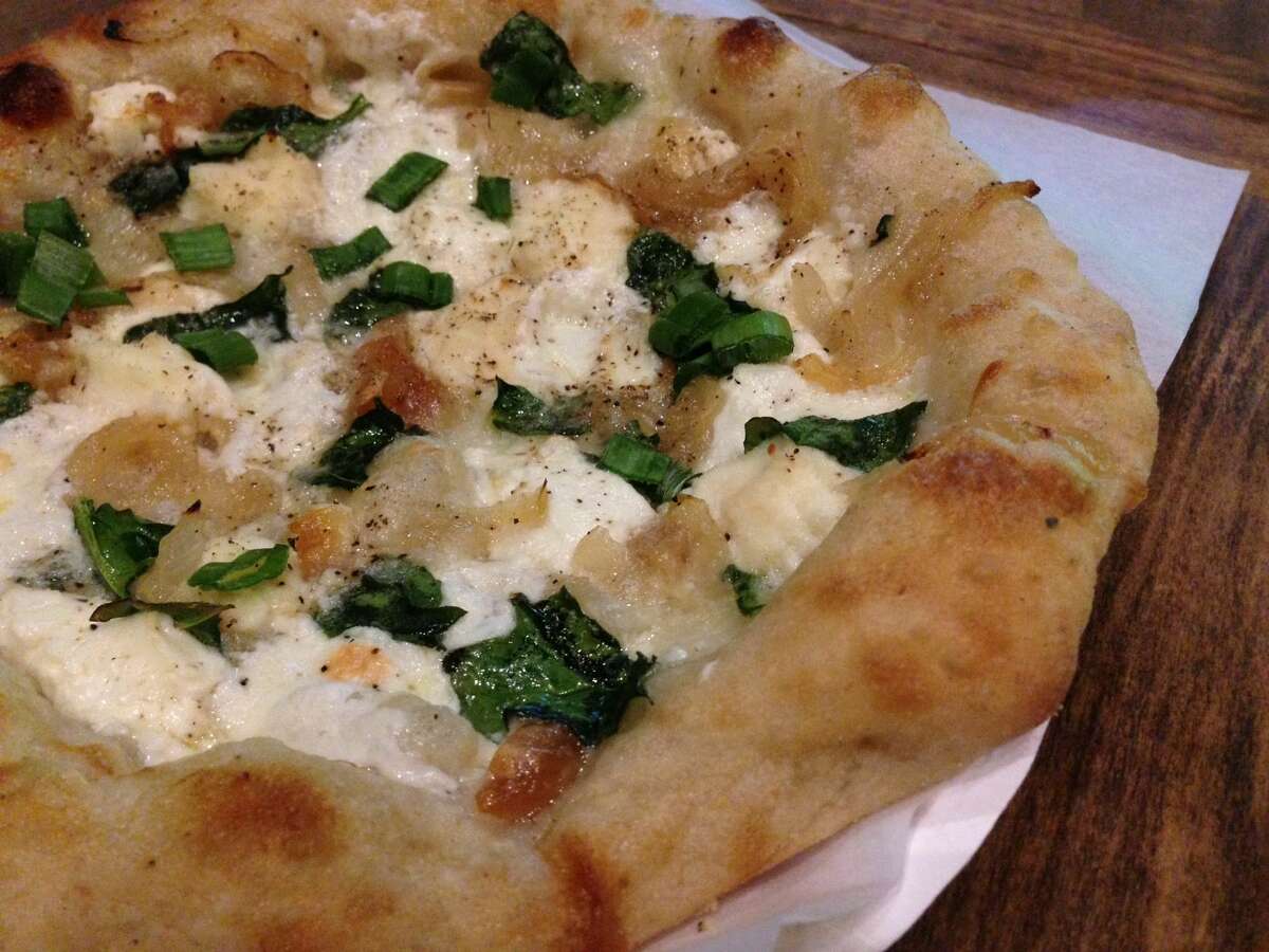 The Bianca Pizza (white sauce, four cheeses, slow-roasted garlic, caramelized onion, spinach and green onion) from Arte Pizzeria, a new concept opening in the Conservatory food hall in downtown Houston.