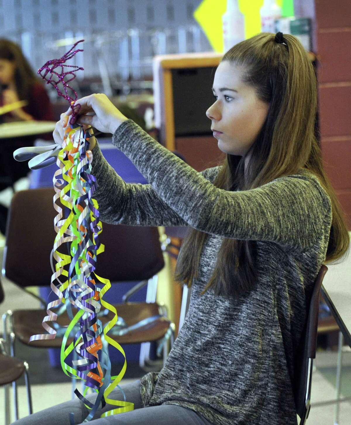 Mia Gajda, 14, curls ribbon for the crowns she is creating for the annual Scotty Fund picnic. Wednesday, April 5, 2017, Freshmen at Bethel High School worked on various volunteer projects.