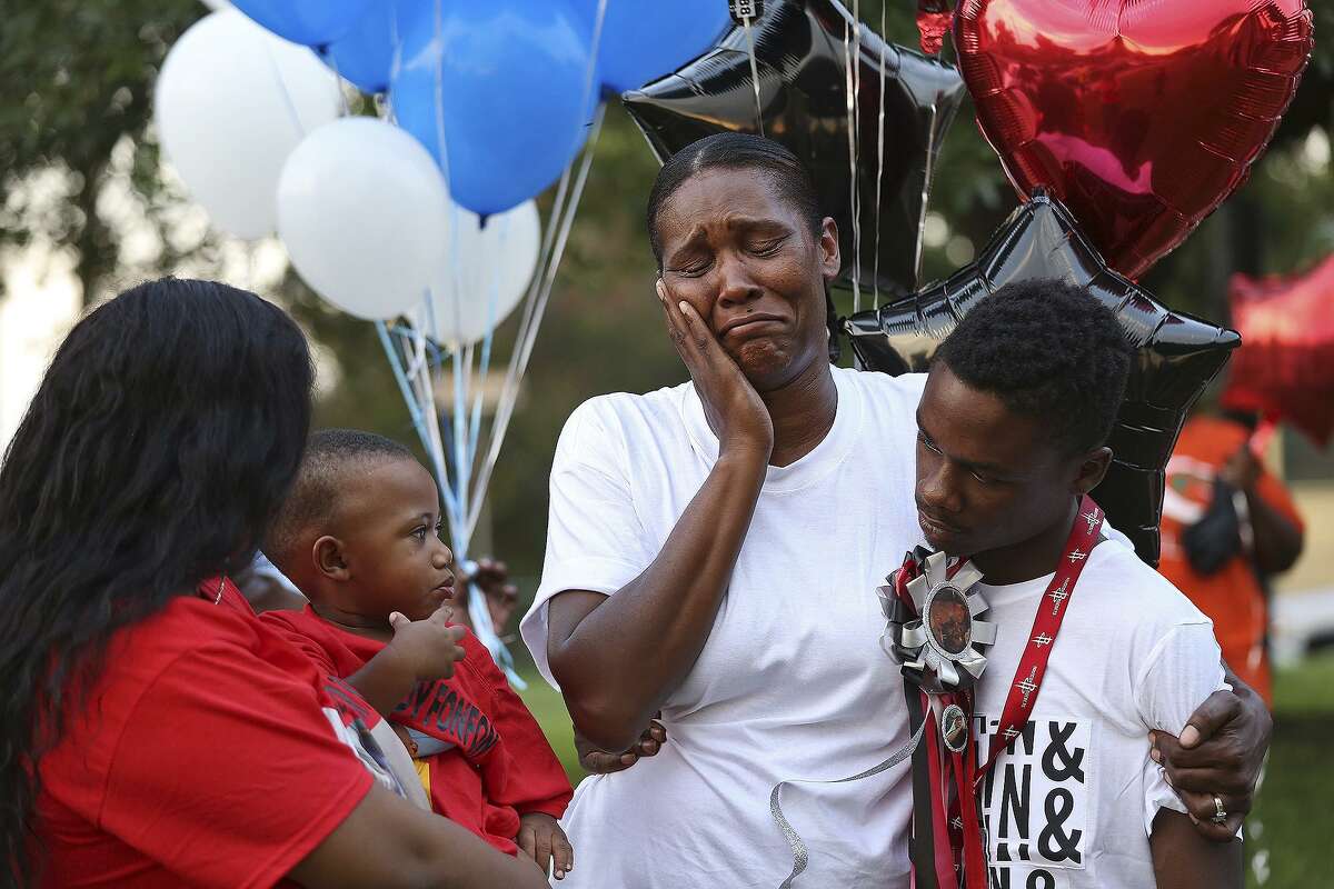 Maria Anderson is comforted by friends and family including John Baker, right, during a balloon release at Lockwood Park for her son Shavone Anderson, 20, who was shot and killed a week earlier. The event was held by StandUP SA on Sept. 2, 2016. At left is Tyraneisha Loving, 22, and son Braylon Easley, 1. Tyraneisha is pregnant with Shavone's son.