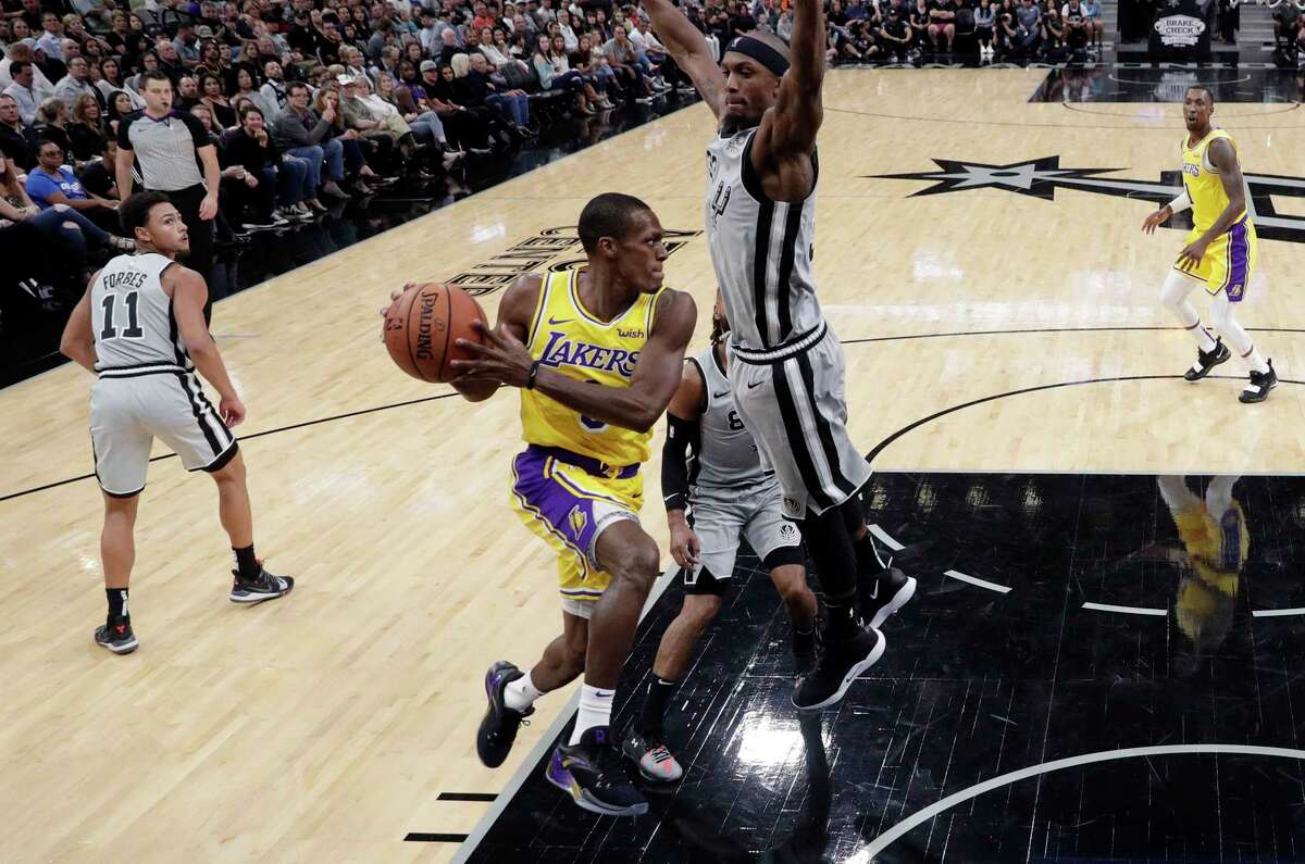 Los Angeles Lakers guard Rajon Rondo, center left, drives to the basket past San Antonio Spurs forward Dante Cunningham, center right, during the first half of an NBA basketball game, Saturday, Oct. 27, 2018, in San Antonio. (AP Photo/Eric Gay)