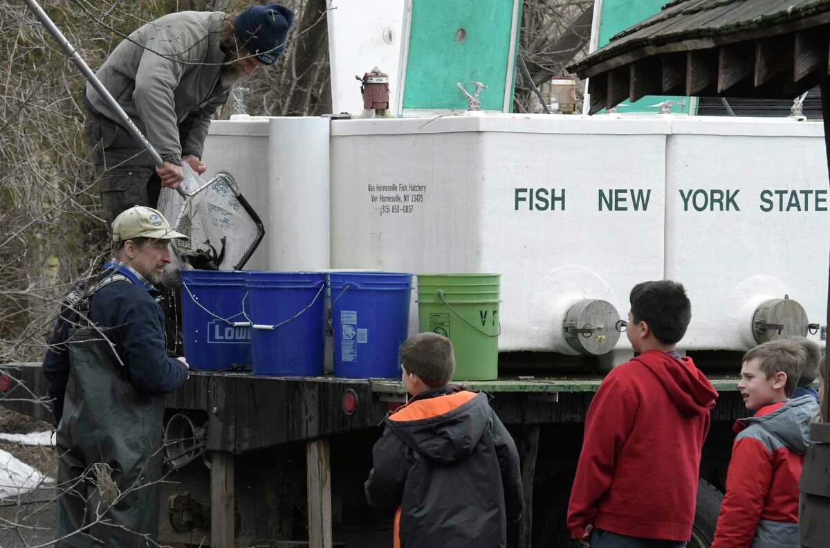 Voorheesville Elementary School students queue up for their turn to release young fish in to the Vly Creek Wednesday April 5, 2017 in Voorheesville, N. Y. Getting the fish in the buckets are ENCON workers Craig dubois, above and Dennis Whishman below. Skip Dickstein/Times Union)