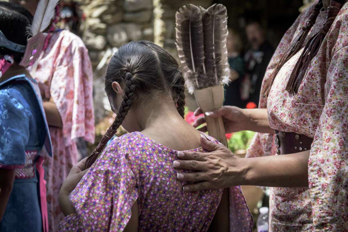 Izel Lopez (right) and her daughter Katia Lopez (center), get ready to perform as part of the American Indians in Texas Dance Theater during the 6th Annual Four Seasons Indian Market at Mission Espada in 2015.
