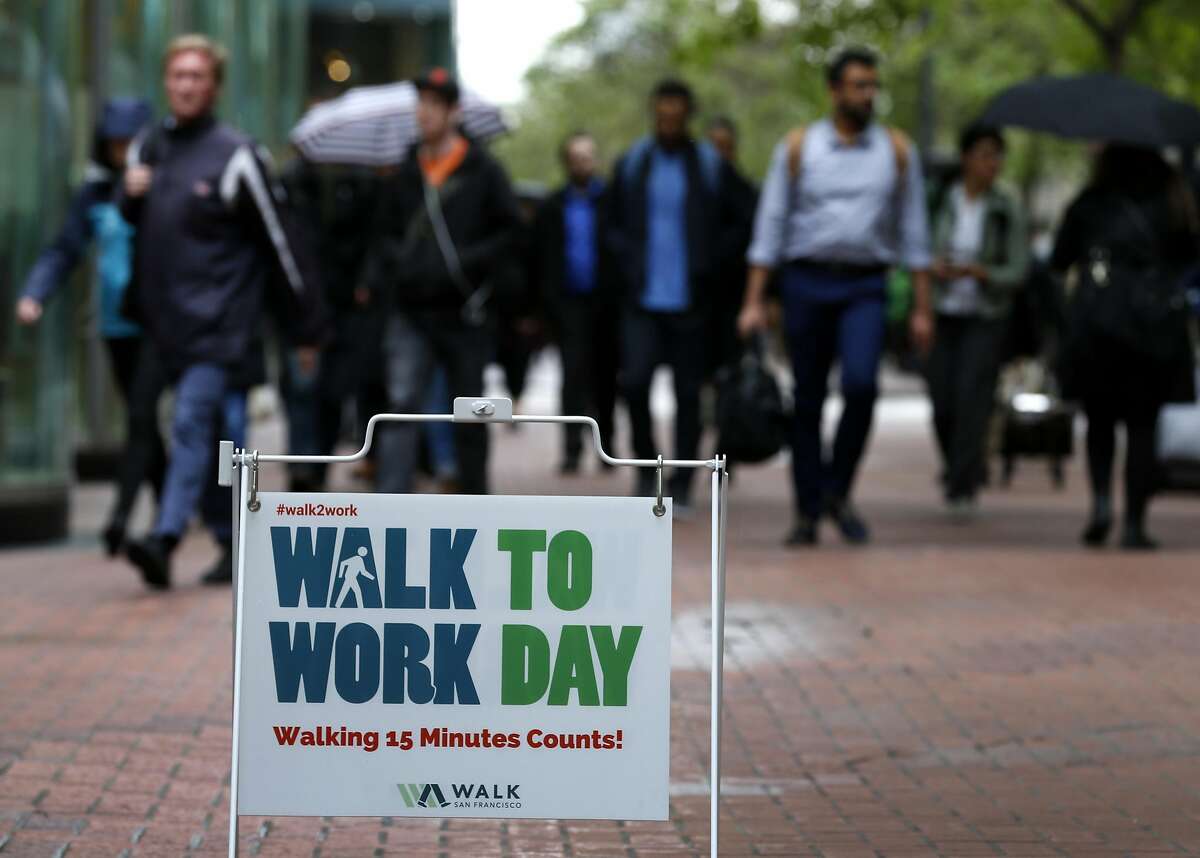 Office workers walk to their jobs on Market Street in the Financial District in San Francisco, Calif. on Thursday, April 6, 2017. Thursday was recognized as Walk to Work Day.