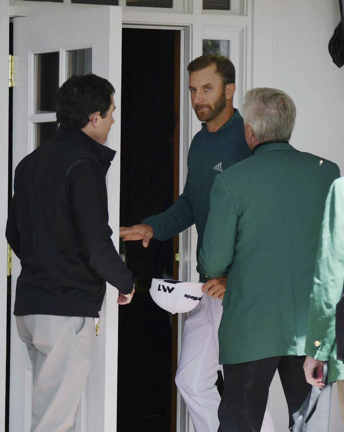 World No. 1 Dustin Johnson enters the clubhouse after deciding his injured back wouldn’t let him play.