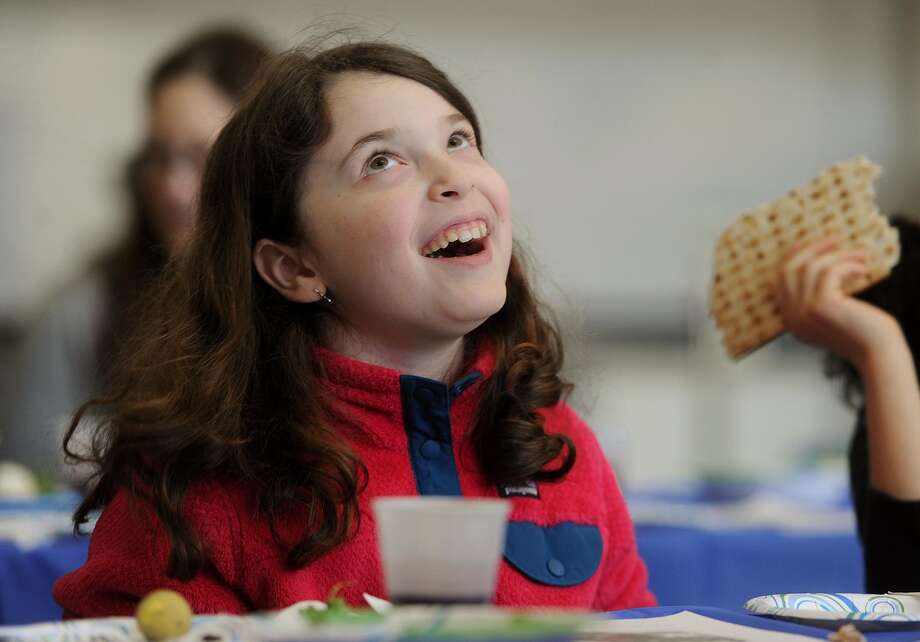 Julia Zagar, 9, of Fairfield, Conn. sings along to a song about matzah during a Passover Seder. Photo: Brian A. Pounds / Hearst Connecticut Media / Connecticut Post