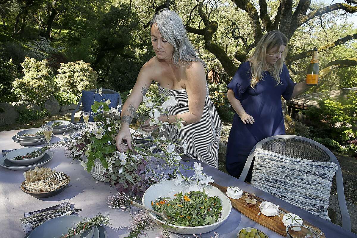 Floral designer Alethea Harampolis (middle) works on arrangement for the spring/summer table setting as author Stephanie Bittner (right) sets the table on Tuesday, April 4, 2017, in Lafayette, Calif.