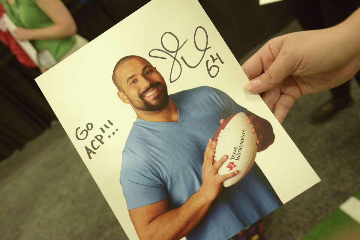 An attendee at the National Council of Teachers of Mathematics annual meeting and exposition holds an autographed portrait John Urschel, a lineman with the NFL Baltimore Ravens and an MIT Ph.D. candidate, at the Henry B. Gonzalez Convention Center on Friday, April 7, 2017.