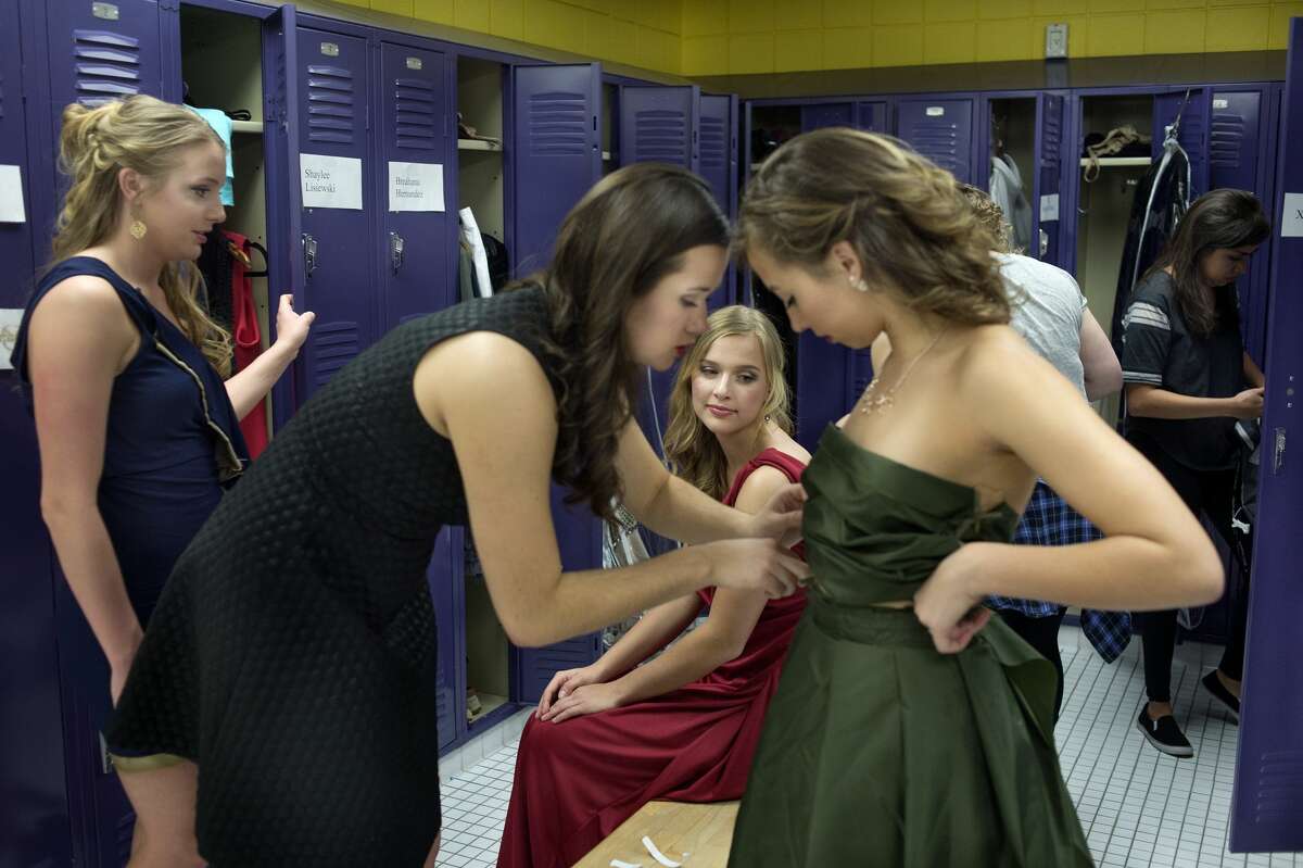 BRITTNEY LOHMILLER | blohmiller@mdn.net Northwood freshman from left: Hailey Hartwick and Christina Medici watch as their roommate Veronica George makes adjust to Karina Parker's dress before the start of the 16th annual Northwood University Style Show Friday evening at the Hach Student Life Center. George created the three dress for the student portion of the show. A total of seven student designers created collections.