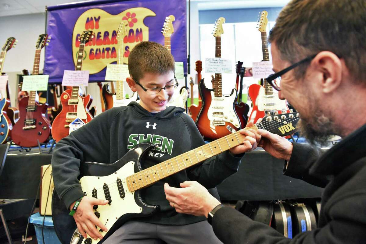 Twelve-year-old Will Meyer of Clifton Park gets help from his father Stephen Meyer, right, in picking out a first guitar at the My Generation Guitars booth during the Capital Region Guitar Show at the City Center Saturday April 8, 2017 in Saratoga Springs, NY. (John Carl D'Annibale / Times Union)