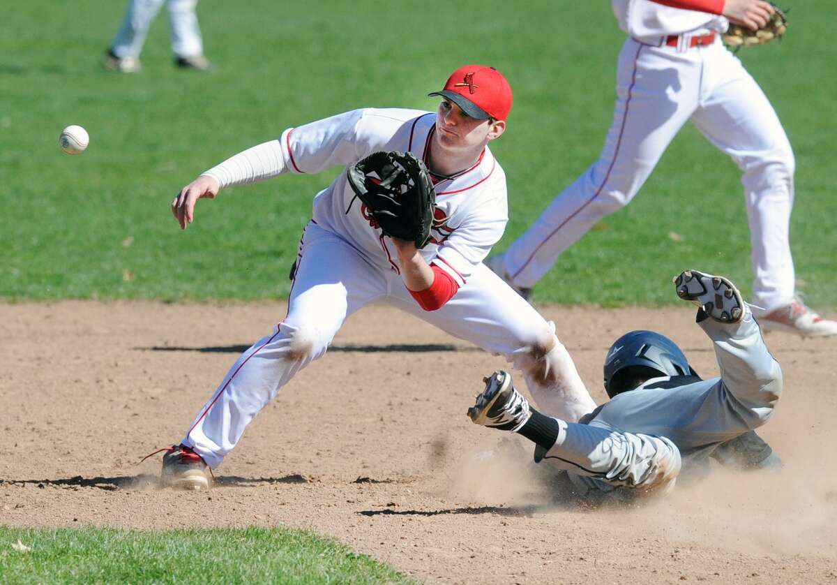 Ricky Columbo of Greenwich, left, takes a throw from Greenwich catcher Paul Williams but is unable to get Xavier runner Drew Michaud who stole second during the top of the second inning of the high school baseball game between Greenwich High School and Xavier High School at Julian Curtiss School in Greenwich, Conn., Saturday, April 8, 2017. Xavier defeated Greenwich by a score of 5-2.