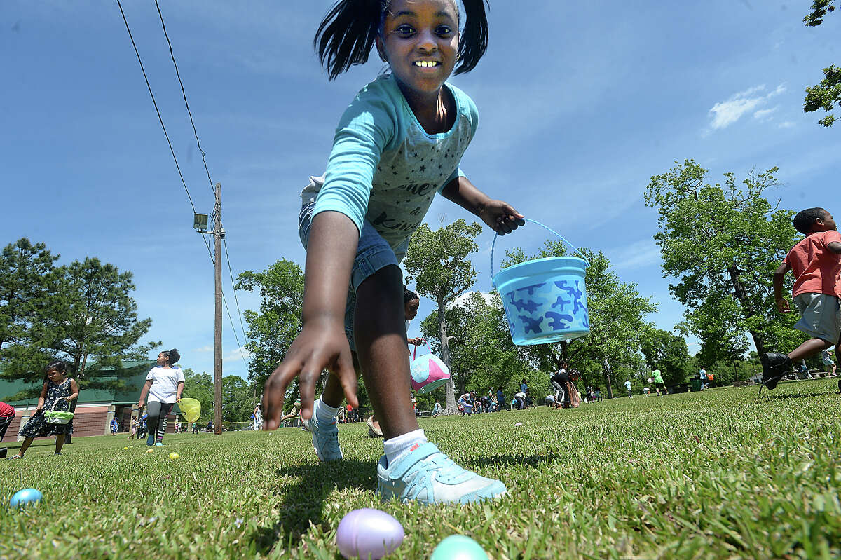 Children scramble toward the treats that await during the City of Beaumont's annual Easter Egg Hunt in Magnolia Park Saturday. Children scrambled throughout the grounds, quickly filling baskets and bags with colorful, treat-filled eggs. Photo taken Saturday, April 8, 2017 Kim Brent/The Enterprise