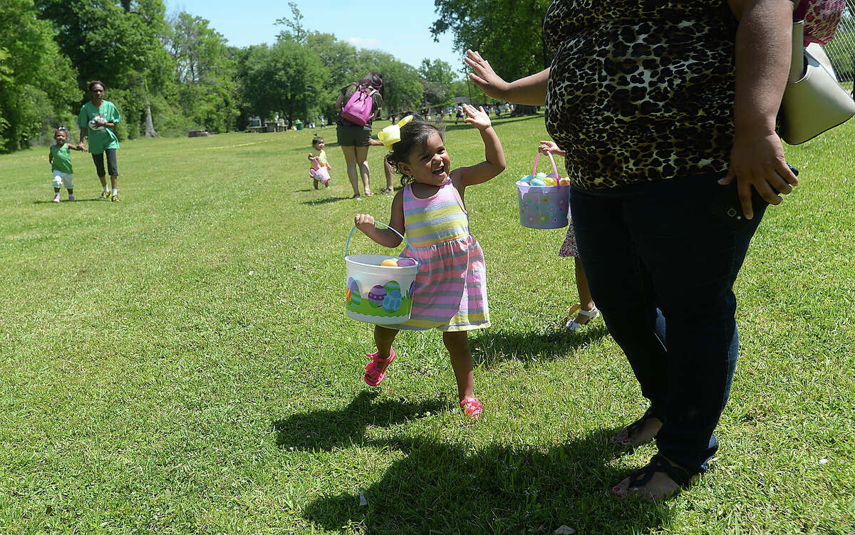 Yareli Mosqueda gets a hug-five from her mother Noheli Mosqueda after filling her basket with eggs during the City of Beaumont's annual Easter Egg Hunt in Magnolia Park Saturday. Children scrambled throughout the grounds, quickly filling baskets and bags with colorful, treat-filled eggs. Photo taken Saturday, April 8, 2017 Kim Brent/The Enterprise