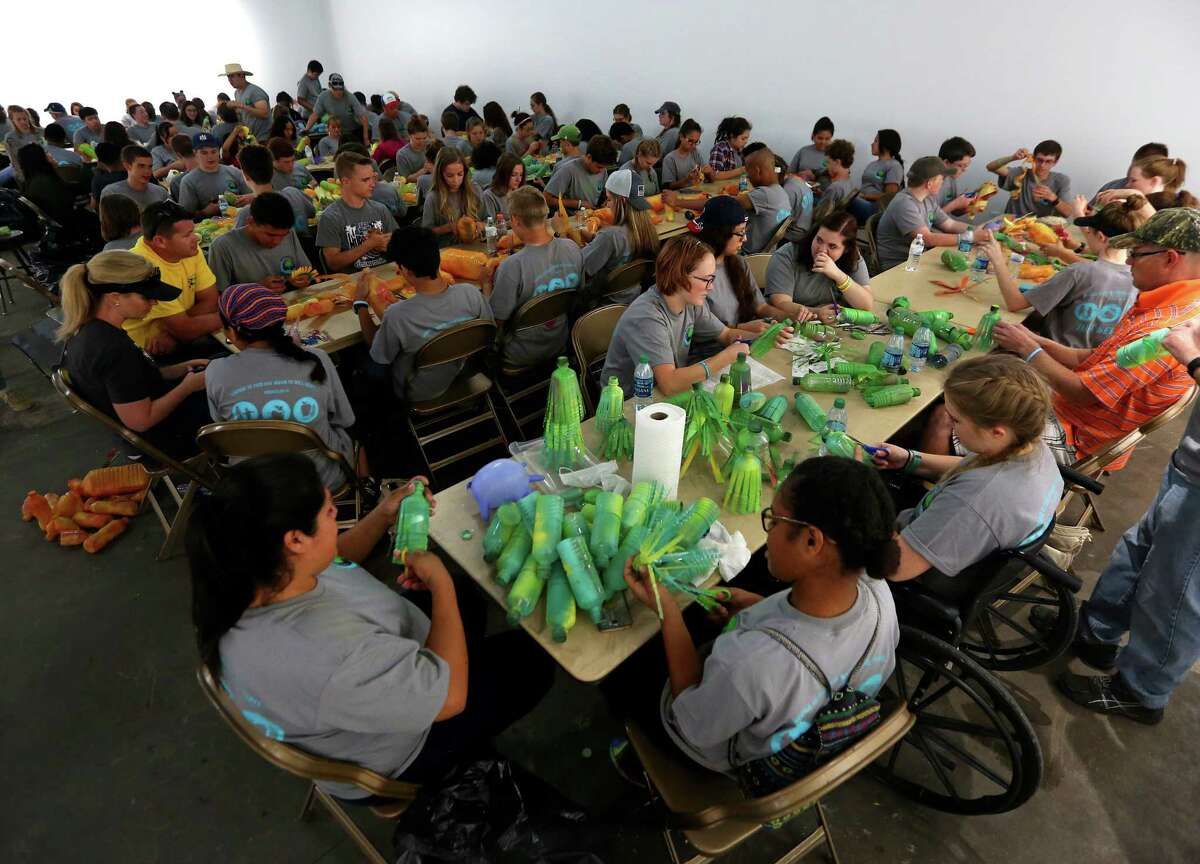 ﻿﻿More than 200 teens ﻿from ﻿Houston-area Mormon churches ﻿painted, cut and﻿ created "flowers" out of used water bottles Saturday. The flowers are to be part of ﻿local artist Carol Simon's ﻿ "First Ward is Blooming" project.﻿