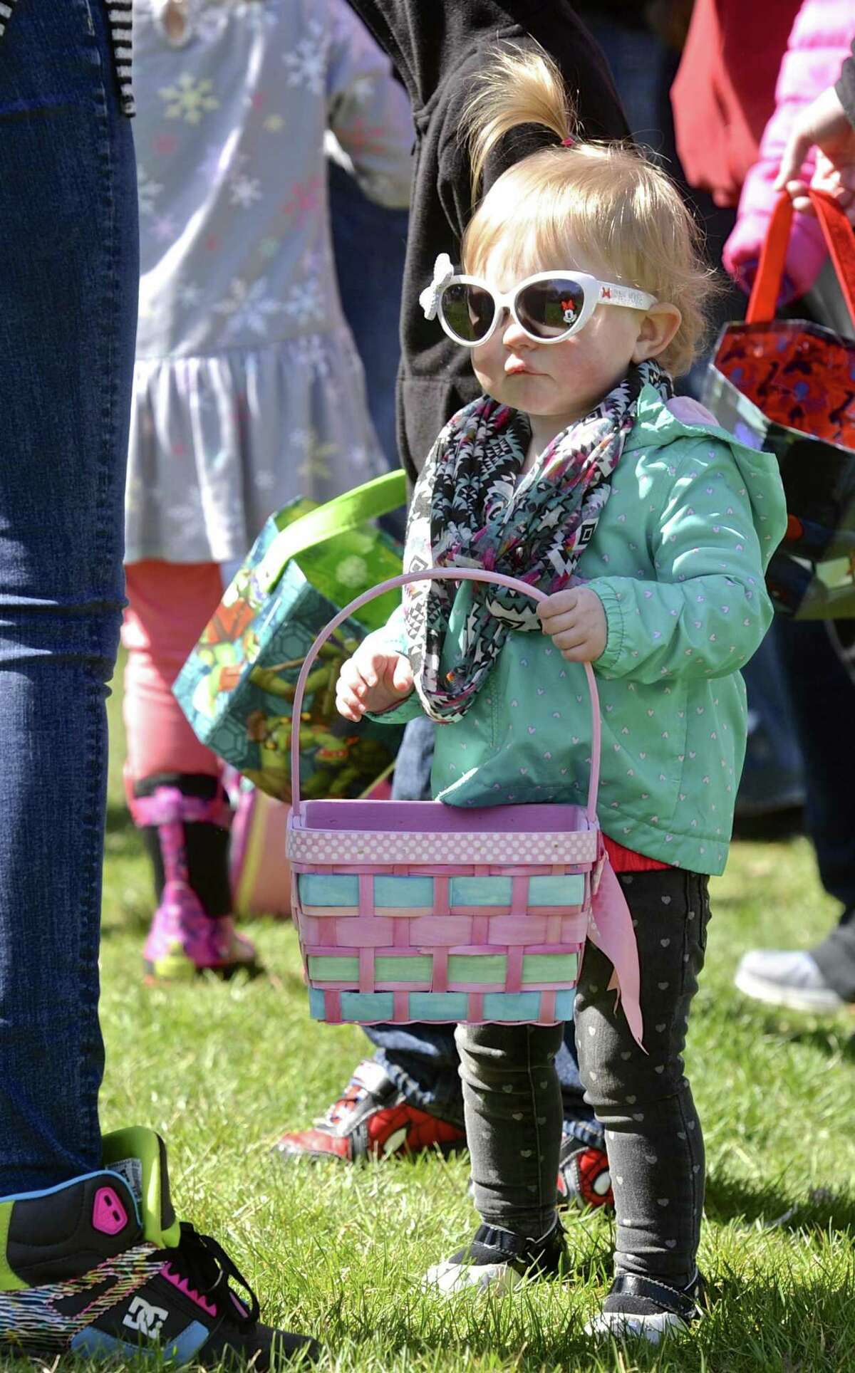 Wearing cool shades 16 month old Abigail Downs, of Danbury, waits with her basket for the start of the Tatiane before the 2017 Macaroni Kid Easter Egg Hunt, held at Tarrywile Park, in Danbury, Conn, on Saturday afternoon, April 8, 2017.