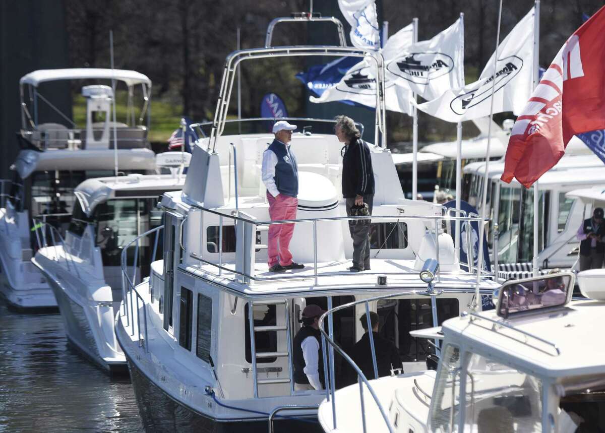 John Farmelo, left, of East Coast Yacht Sales, chats with New York's Paul Dunne atop the American Tug 395 at the Greenwich Boat Show at the Greenwich Water Club in Greenwich, Conn. Sunday, April 9, 2017. The ninth-annual show featured more than 100 boats, representing 42 brands from 19 dealers in the region. Prospective buyers were given a chance to test ride the boats in Cos Cob Harbor.