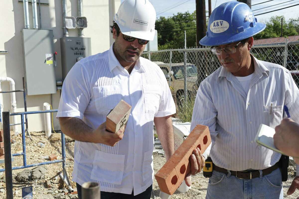 Local developer Kevin Covey, left, checks out a D’Hanis brick that he picked out himself at the company’s factory for a retail center he’s building in Southtown. His construction manager, Adrian Perez, is at right.