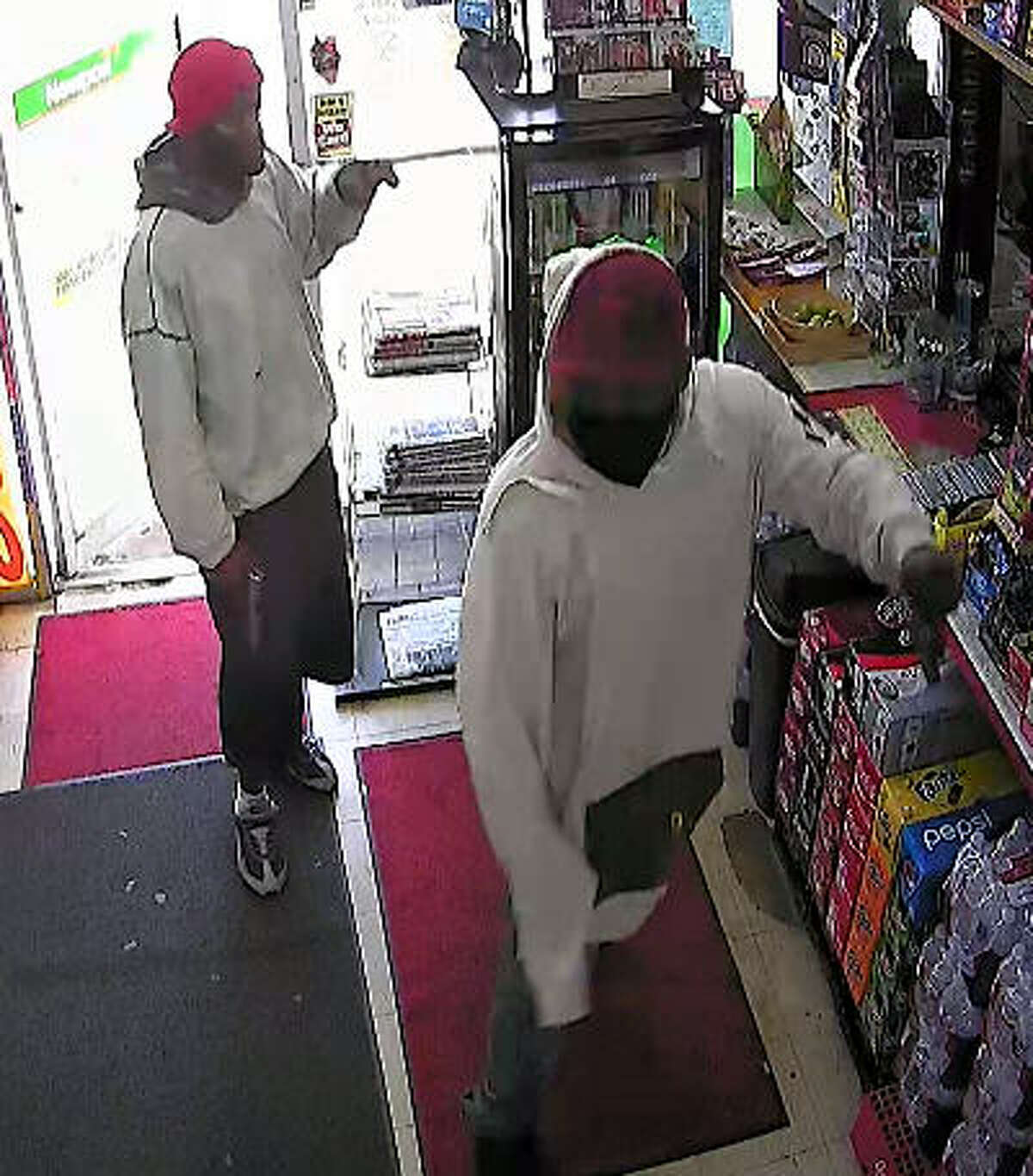 Police described the two robbers who stormed into a Baytown store and shot the clerk on April 9 as two black males, the first approximately 5’10, approximately 200 pounds, wearing a gray hoodie, baggy shorts and a red hat. The second suspect, also about 5’10”, weighing approximately 250 pounds, was wearing a white hoodie, dark shorts and a black mask covering his face, police said.