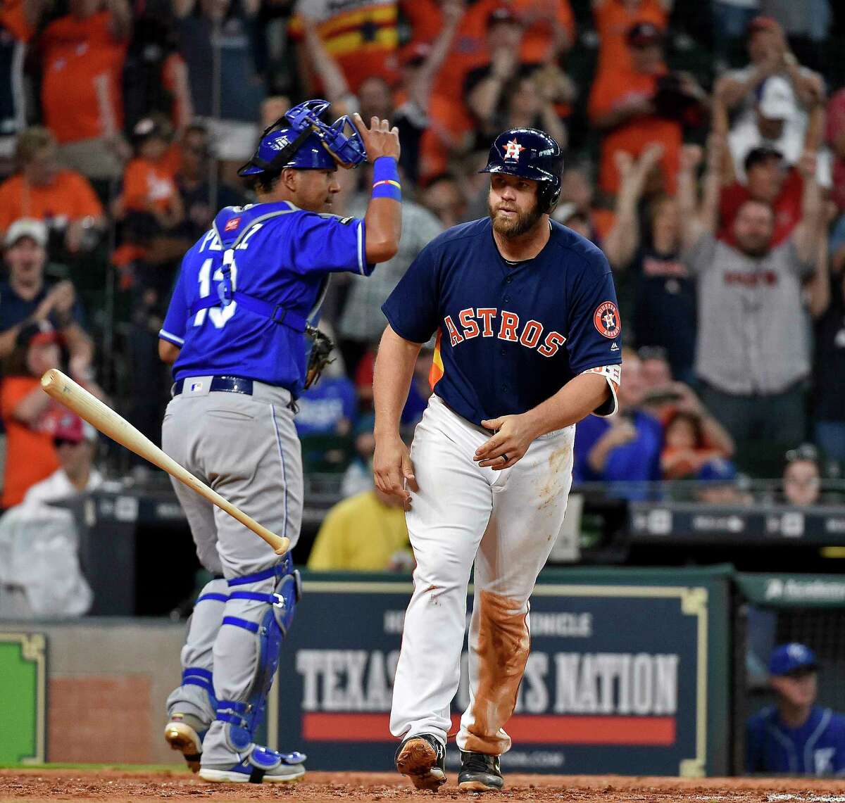 Houston Astros designated hitter Evan Gattis tosses his bat after drawing a bases-loaded walk to score George Springer and win the baseball game against the Kansas City Royals in twelve innings, Sunday in Houston.
