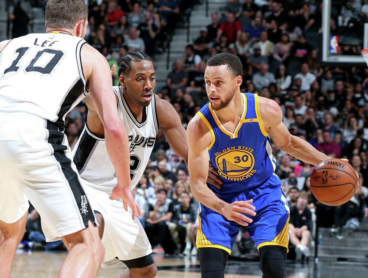 The top-seeded Warriors’ Stephen Curry looks for room around David Lee and Kawhi Leonard of the Spurs, the No. 2 seed, on March 29 at the AT&T Center.