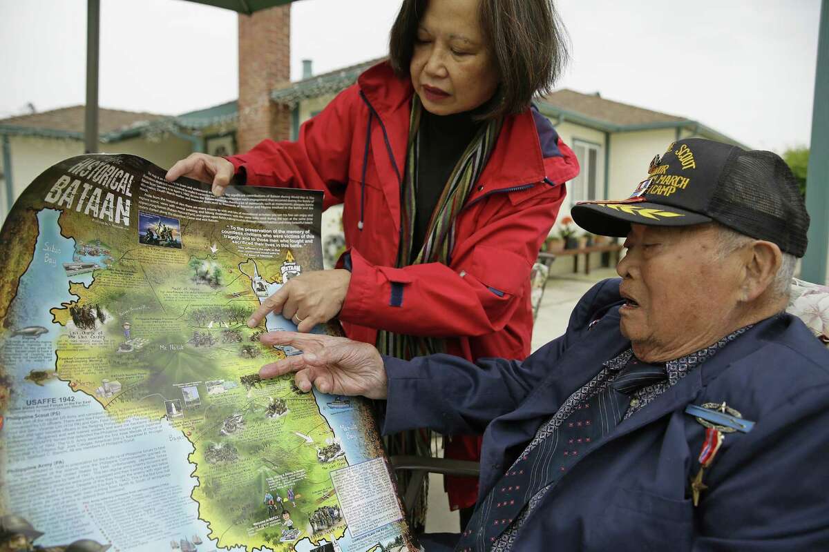 With Cecilia Gaerlan at his home in El Cerrito, Calif., Bataan Death March survivor Ramon Regalado looks at a map showing the route where thousands died as prisoners of Japan.