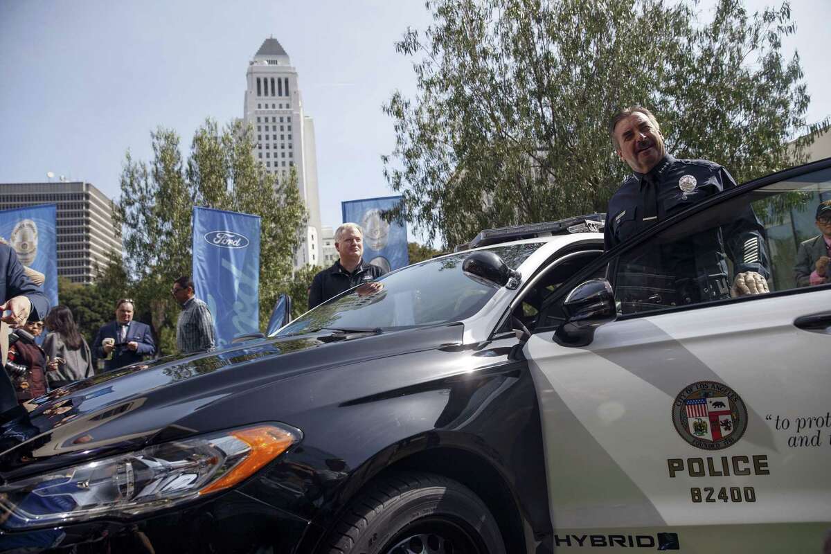 Charlie Beck, chief of Los Angeles Police Department, stands next to the new Ford Police Responder hybrid vehicle during a Monday event outside of LAPD headquarters in Los Angeles. Ford says it expects its new Police Responder hybrid sedan, a modified Fusion, will become the first gasoline-electric cop car to be “pursuit-rated,” meaning it can race through city streets while navigating crowded intersections or hopping curbs.