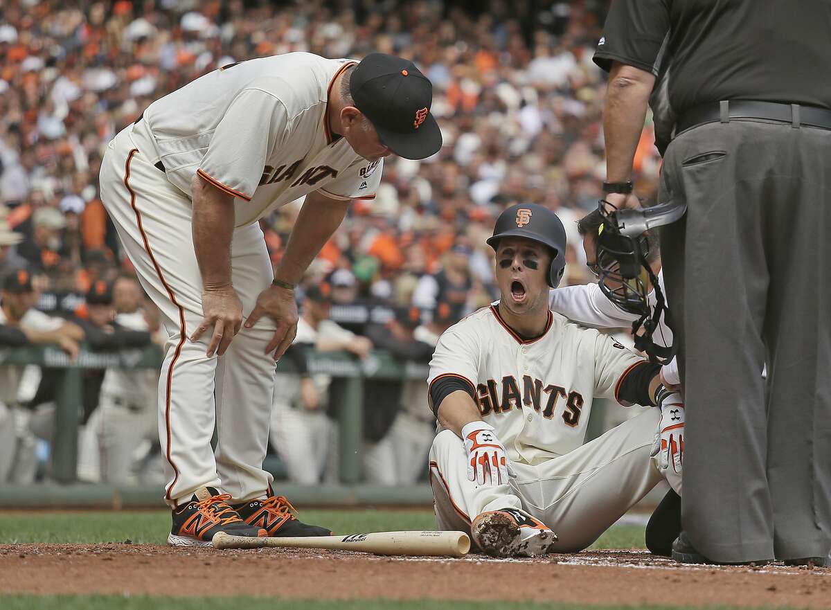 San Francisco Giants manager Bruce Bochy, left, checks Buster Posey on the ...