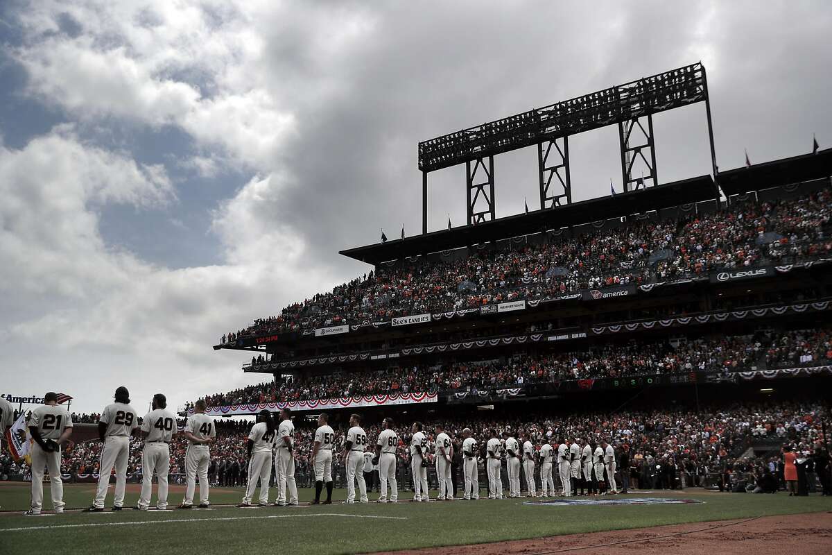 The Giants line up on the baseline during the national anthem before they played the Arizona Diamondbacks on Opening Day at AT&T Park on Monday, April 10, 2017.