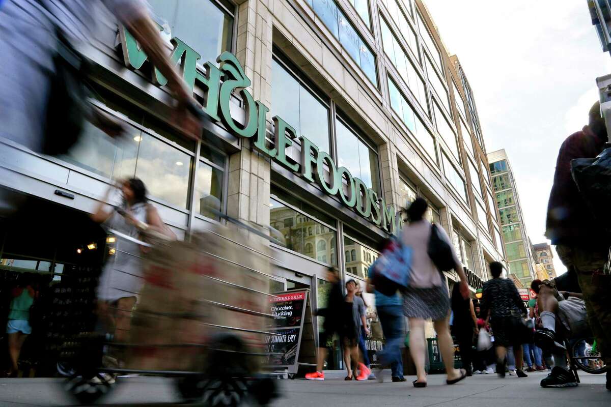 Pedestrians pass a Whole Foods Market in New York's Union Square. The Austin-based chain has been dealing wih its worst sales slump in more than a decade.