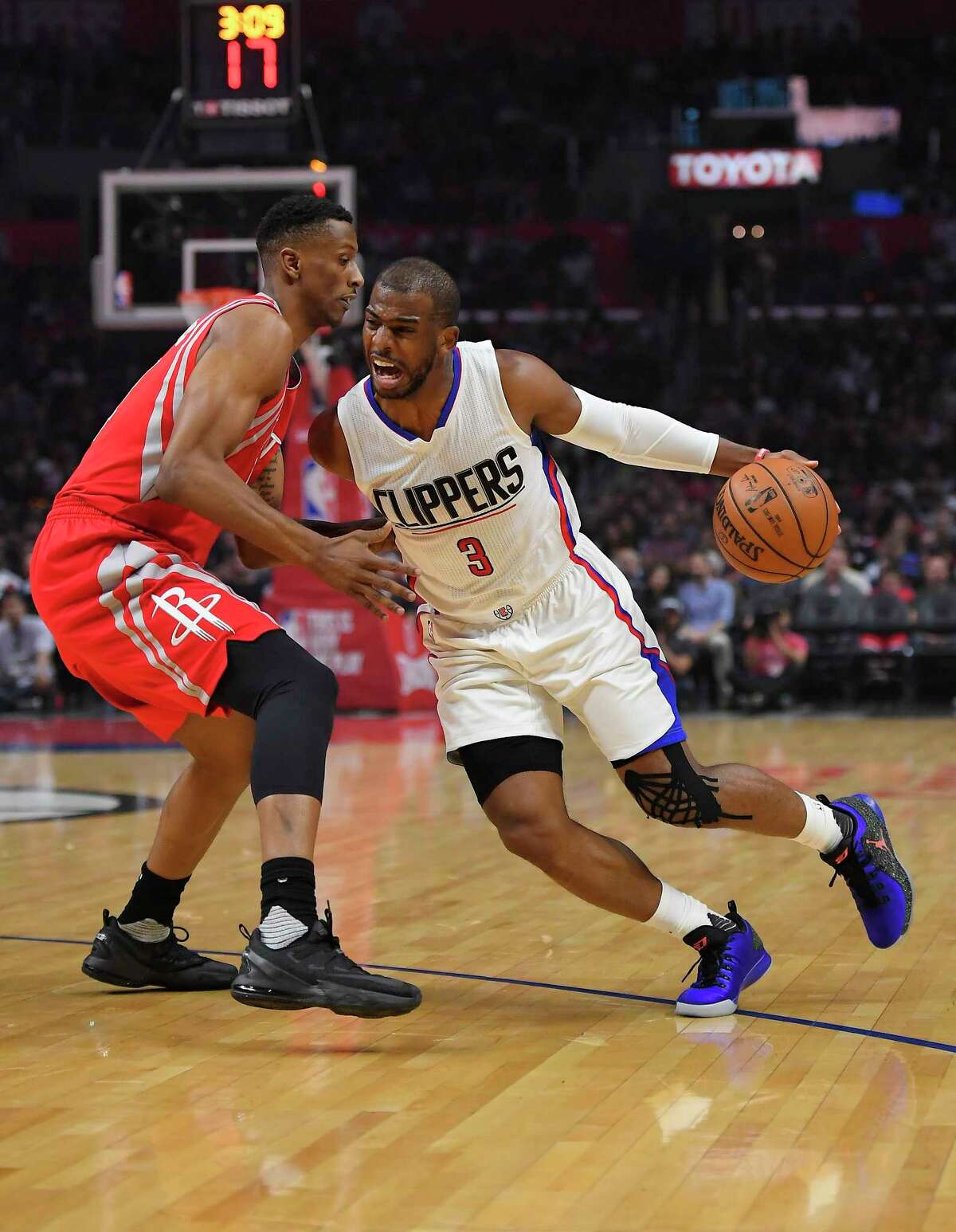 Los Angeles Clippers guard Chris Paul, right, tries to drive past Houston Rockets forward Troy Williams during the first half of an NBA basketball game, Monday, April 10, 2017, in Los Angeles. (AP Photo/Mark J. Terrill)