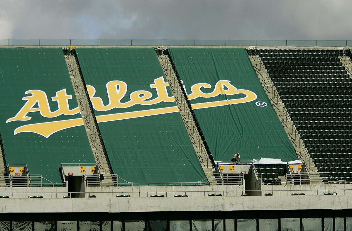 ** ADVANCE FOR WEEKEND EDITIONS, MARCH 18-19 ** Workers affix a green tarp over upper deck seats at McAfee Coliseum Wednesday, March 15, 2006, in Oakland, Calif. By the time the Oakland Athletics open their season against the New York Yankees next month, the team will have strung a tarpaulin over 10,000 of the most unattractive upper-deck seats, reducing McAfee Coliseum to one of the smallest in pro baseball. Counterintuitive as it may sound, the A's, who have struggled with low attendance, hope the removal of the stadium's entire third deck will boost season ticket sales and generate renewed fan loyalty. (AP Photo/Ben Margot)Ran on: 03-19-2006 Workers affix a green tarp over upper deck seats at Oaklands McAfee Coliseum. The As are stringing tarpaulin over 10,000 upper-deck seats, reducing the park to one of the smallest in pro baseball.