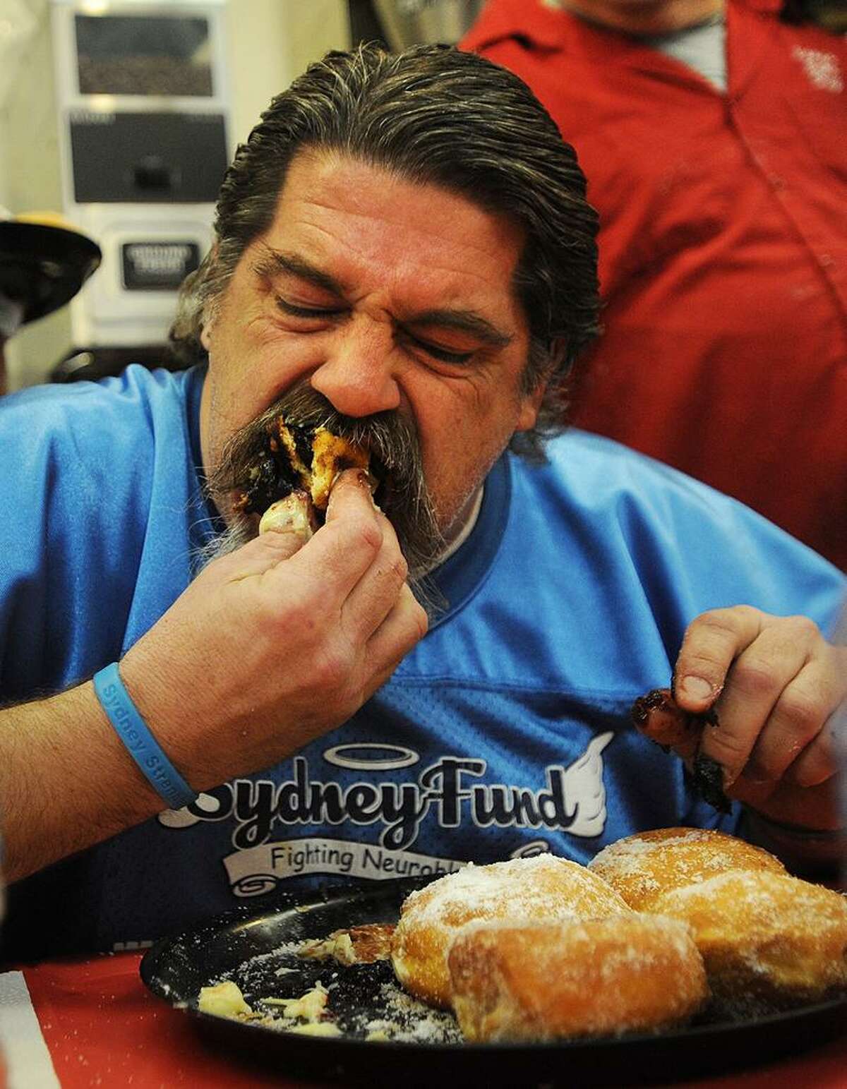 Marcus Bartone, of Derby, digs in to a plate of paczkis, or Polish filled doughnuts, during the 19th annual Paczki Eating Contest at Eddy’s Bake Shop in Ansonia in February.