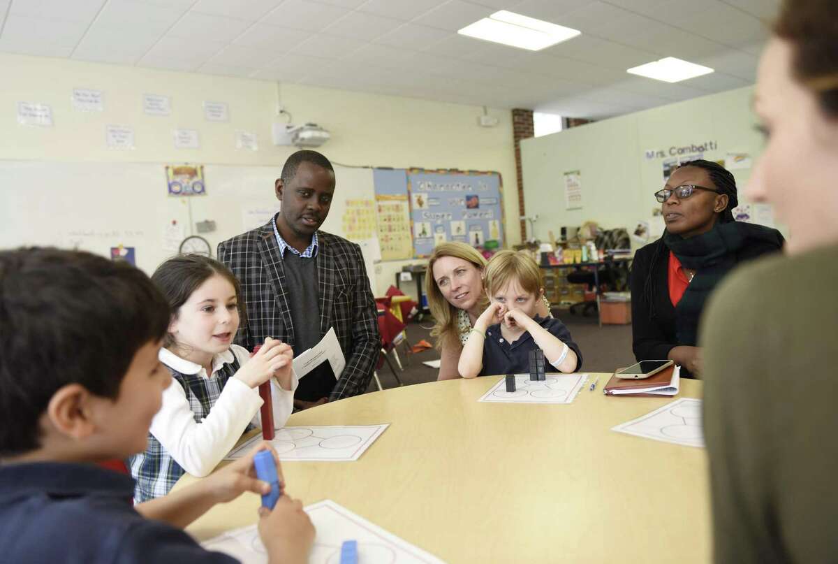 From left, kindergarteners Ryan Robertson, Avery Davis, Inspire Educate and Empower (IEE) Rwanda Executive Director Emmanuel Murenzi, Stanwich Head of Lower School Trudy Davis, kindergartener Ollie Sanders, and IEE Teacher Trainer Racheal Owomugisha work together in class at Stanwich School in Greenwich, Conn. Tuesday, April 11, 2017. The two IEE educators are involved with the Blessing School, built by Stanwich School in rural Rwanda, and are observing the American education system and exchanging teaching ideas with faculty at Stanwich.