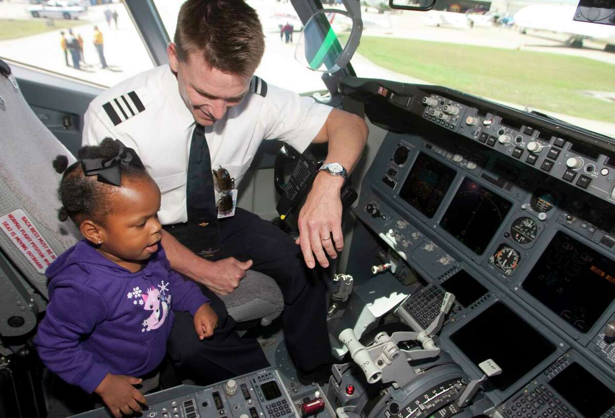 Southwest Airline's First Officer Dan Jensen shows Kenadee Josey around the cockpit of a Boeing 737-700 series during the HobbyFest at Hobby Airport.