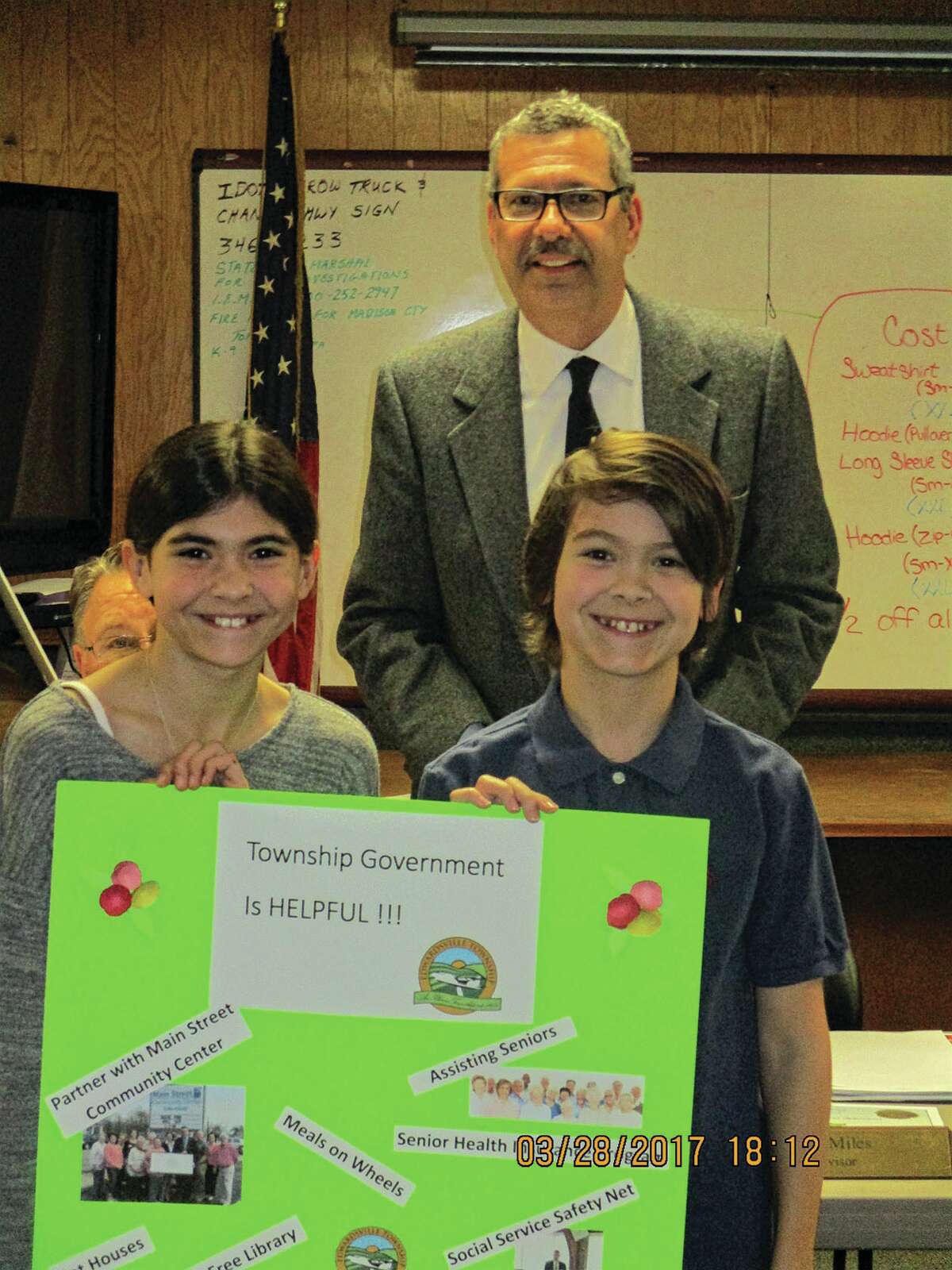 Frank Miles presents certificates and prizes to winners of the Township in Action poster contest: Mercedes and Maximus Mueller.