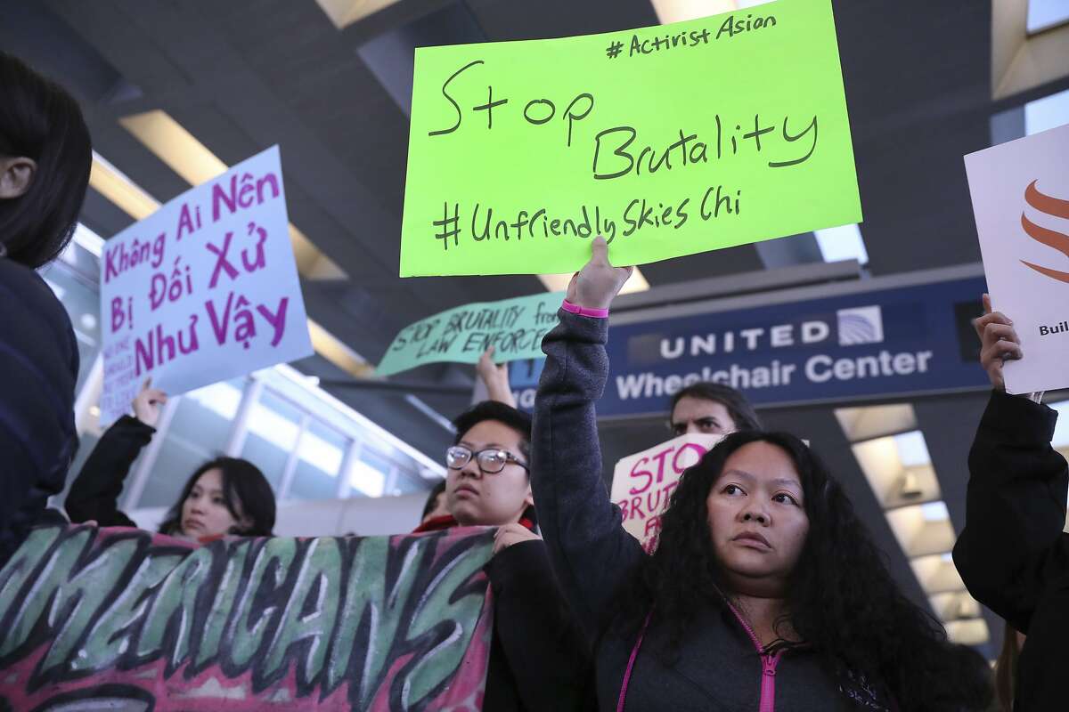 People with Asian community organizations from Chicago hold signs to protest after Sunday's confrontation where David Dao, 69, of Elizabethtown, Ky., was removed from a United Airlines airplane by Chicago airport police at O'Hare International Airport, during rally near United's counter at the airport's Terminal 1 in Chicago on Tuesday, April 11, 2017. (Chris Sweda/Chicago Tribune via AP)