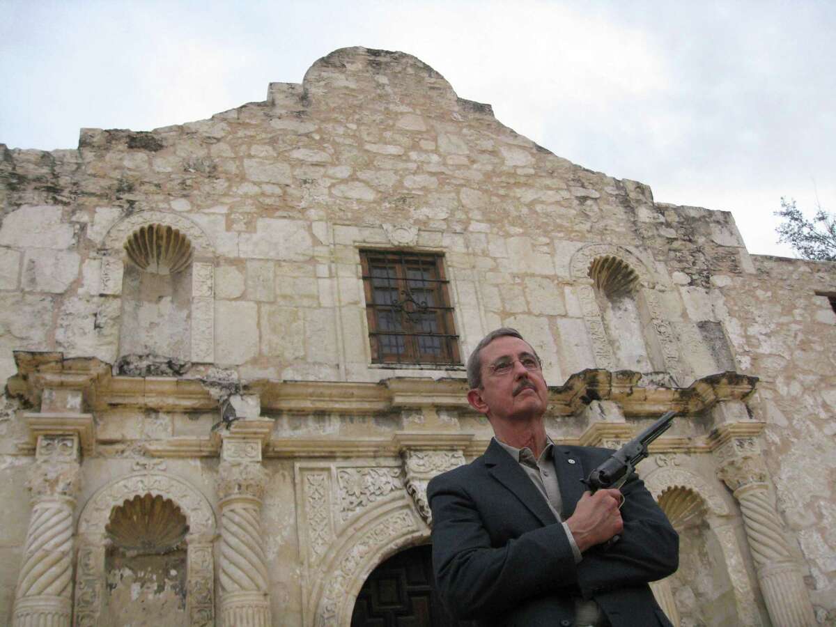 Former Land Commissioner Jerry Patterson poses outside the Alamo in 2014 with a reproduction of a 1847 Colt Walker. At 4.5 pounds, the pistol is “not exactly a concealed carry,” Patterson said.