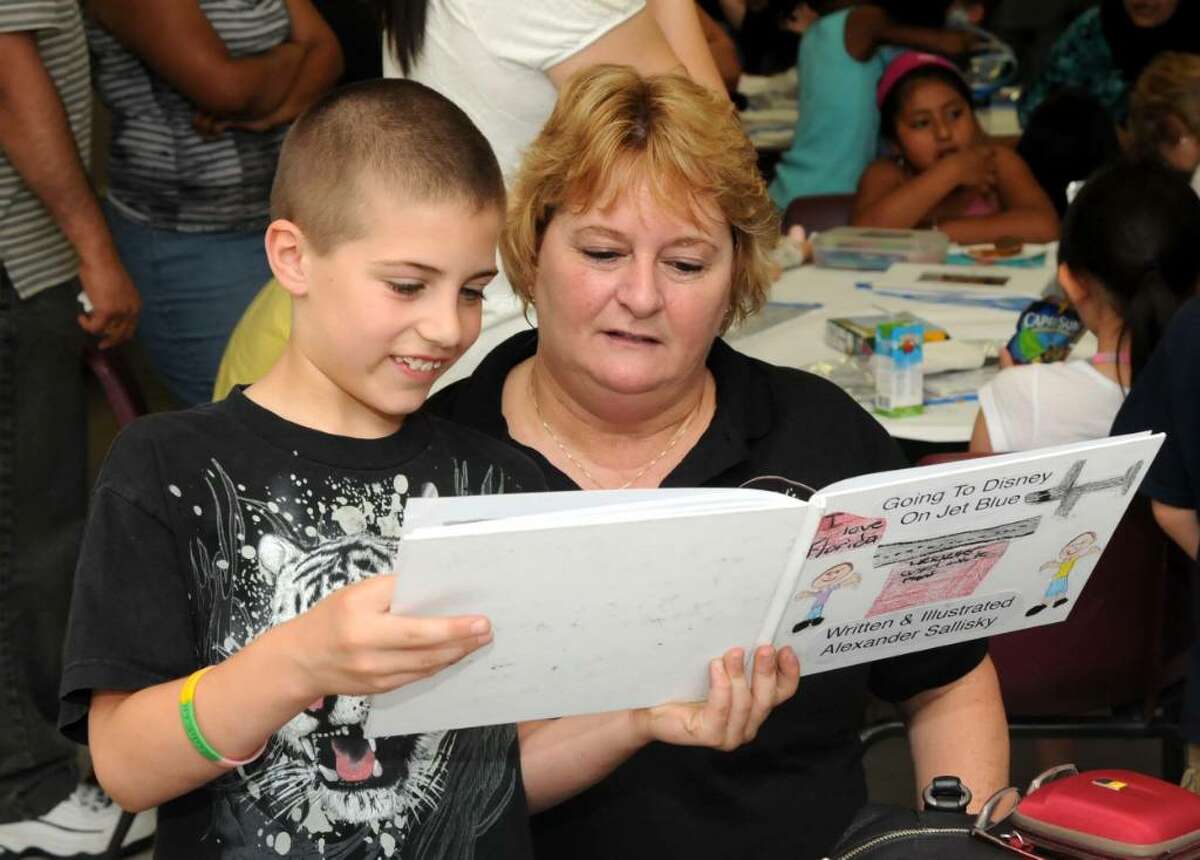 Alex Sallisky, 8, reads his book to his grandmother, Eileen Fuller of Danbury during a celebration at Hayestown Avenue School. Second-graders at the Danbury school typed and illustrated their own books. On Thursday, June 3, 2010, the children gathered in the cafateria where they could share their books with family, friends and school staff members.