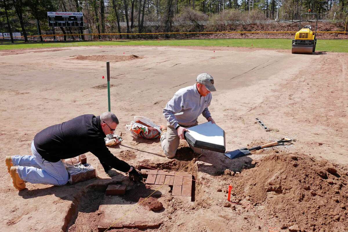 Volunteers Tom Fogarty, left, and Matt Callahan, general manager of the Tri-City ValleyCats, work on the clay bricks under home plate at the Colonie Little League Pee Wee Field in Cook Park on Thursday, April 13, 2017, at the in Colonie, N.Y. (Paul Buckowski / Times Union)