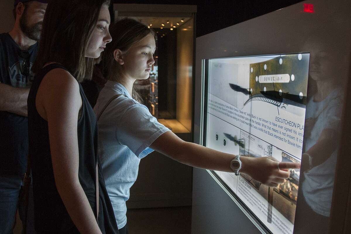 Samantha Merrill, 14, and Grace Ross, 14, visiting from Beaumont, look at an interactive touchscreen in the Jim Bowie exhibit at the Alamo April, 7. These kiosks house artifacts and feature screens that use translucent touchscreen technology allowing patrons to click the screen for detailed information.