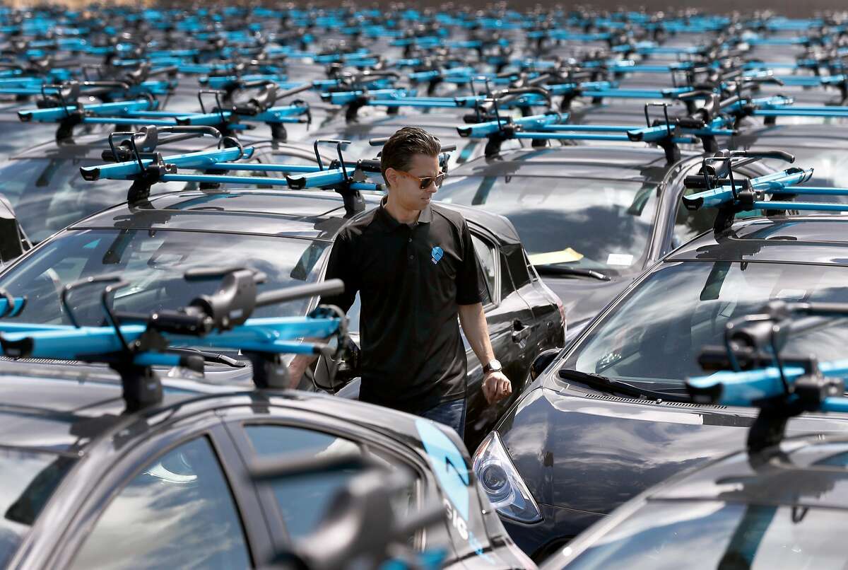 Head of operations Edmund Solis walks among the fleet of a Gig car share vehicles at a AAA storage yard in Oakland, Calif. on Thursday, April 13, 2017. The fleet of 250 Priuses, each with two bike racks mounted to the roof, takes to the streets of Berkeley and Oakland on April 30, when the automobile club's car sharing service launches.