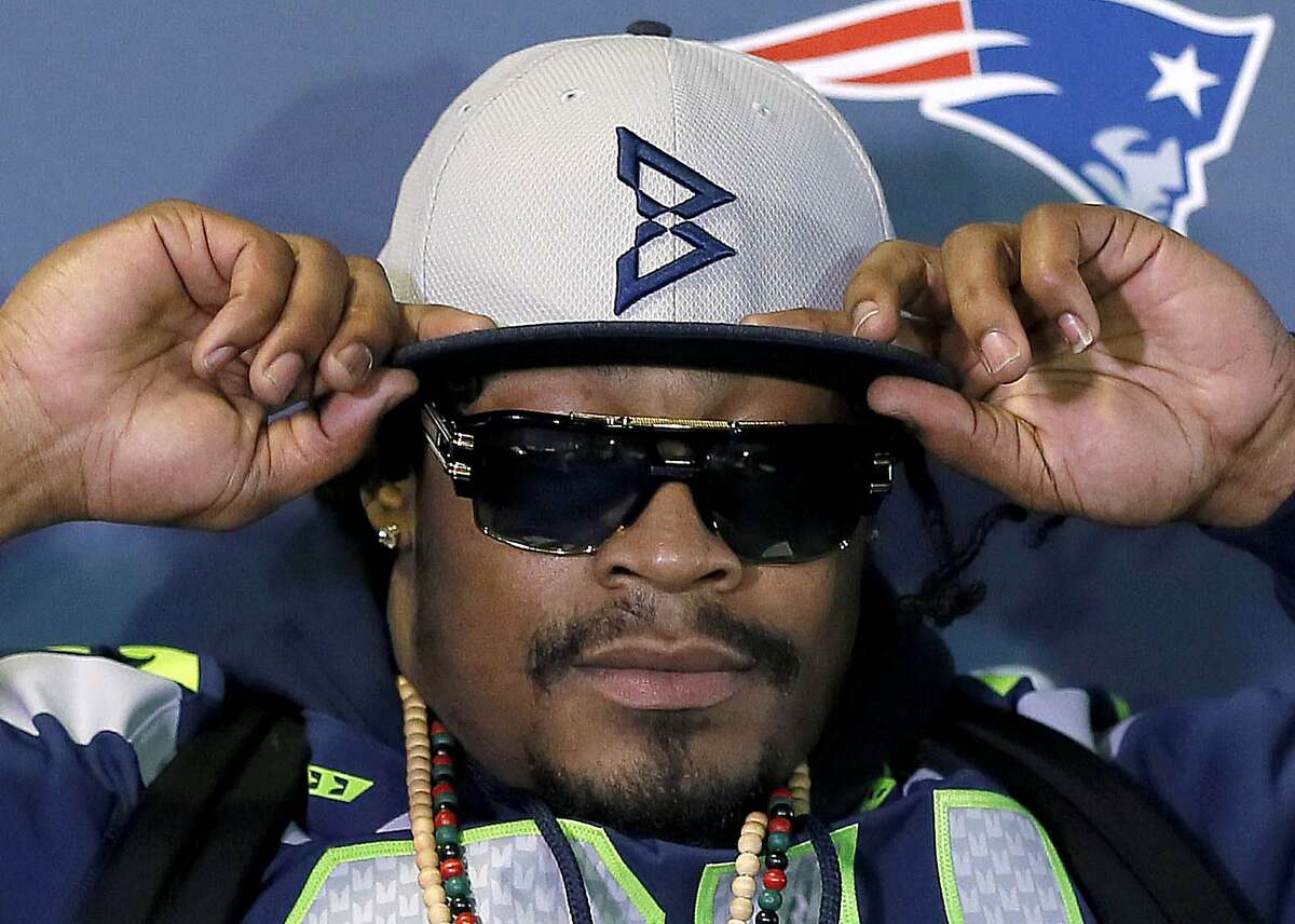 Seattle Seahawks' Marshawn Lynch adjusts his cap during an interview for the NFL Super Bowl XLIX football game, Thursday, Jan. 29, 2015, in Phoenix. The NFL may not like those "Beast Mode" caps Lynch has been wearing during his Super Bowl press appearances, but the fans apparently do. As the league reportedly considers fining Lynch for promoting an unauthorized brand, the New Era Cap Co. is busy making more of the caps after they sold out on Lynch's website. 