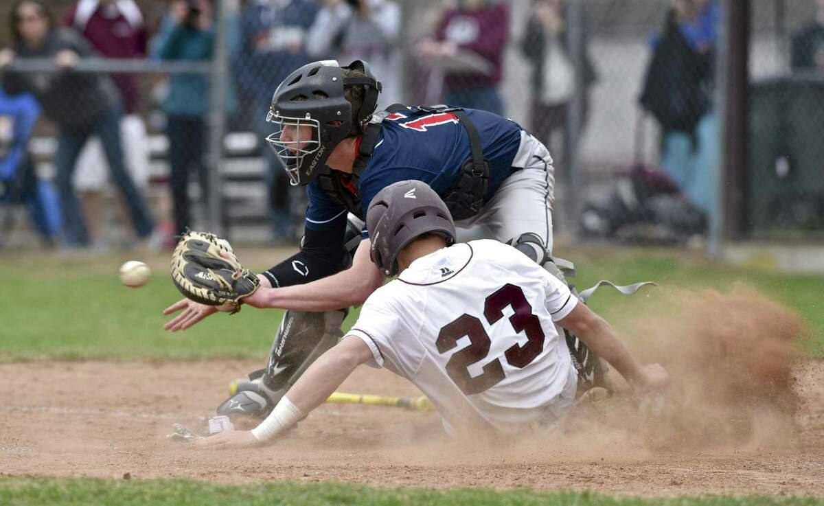 Bethel's Noah Jensen (23) slides across home for the tying run in the seventh inning as New Fairfield catcher Jered O'Connor (13) reaches for the throw, in the boys high school baseball game between New Fairfield and Bethel high schools, Thursday, April 13, 2017, at Bethel, High School, Bethel, Conn. Bethel went on the win the game 5-4.