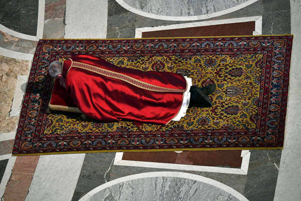 Pope Francis prostrates himself in prayer during the Good Friday Passion of Christ service inside St. Peter's Basilica at the Vatican on Friday.
